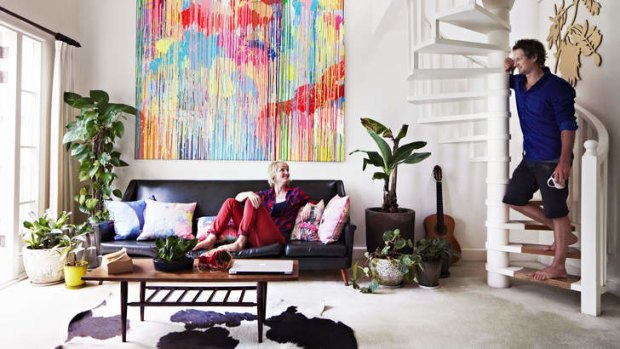 Flat chat … Rowena Martinich, sitting below her painting "Flourish", and Geoffrey Carran in their mezzanine apartment.