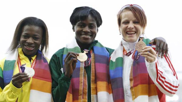 Silver medallist Natasha Mayers of Saint Vincent and the Grenadines (left to right), gold medallist Osayemi Oludamola of Nigeria and bronze medallist Katherine Endacott of England pose with their medals for the women's 100 metres event.