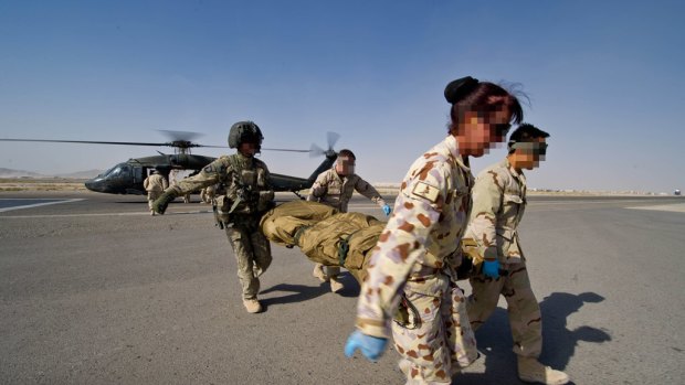 In harm’s way ... a wounded coalition soldier is evacuated by Australians from Afghanistan. Troops are taken from there to the Australian medical base in Dubai.