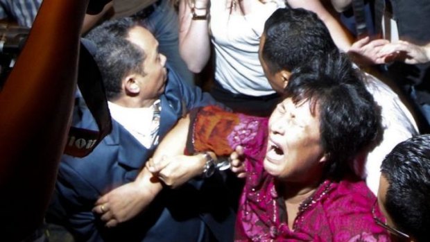 Liu Guiqiu is carried from a press conference by security officials in Malaysia.