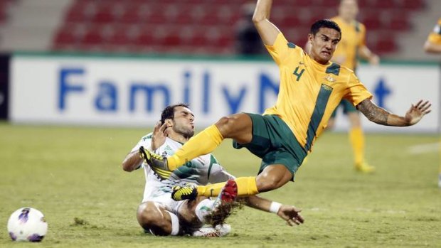 Australia's Tim Cahill is brought down by Iraq's Samal Saeed.