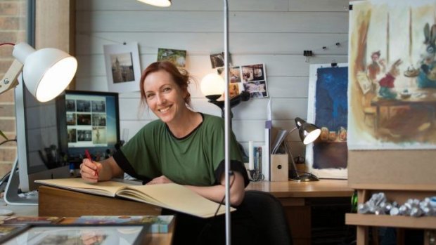 Elise Hurst  in her studio with her work.