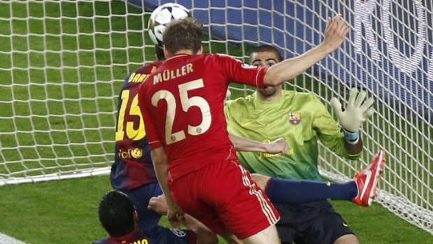 Bayern Munich's midfielder Thomas Mueller heads the ball to score.