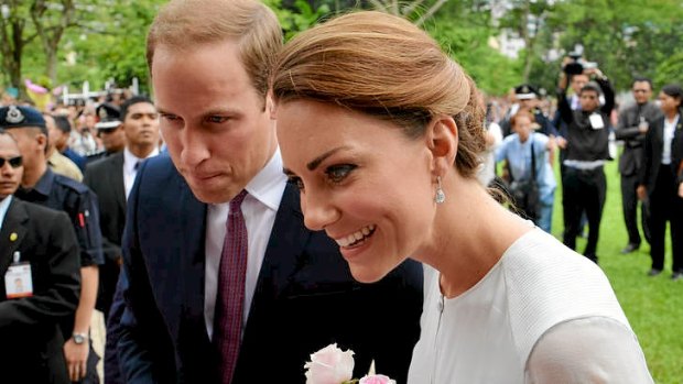 Britain's Prince William and his wife Kate, the Duke and Duchess of Cambridge, smile to the public during a walk through a central city park in Kuala Lumpur, Malaysia.