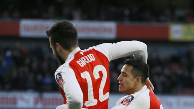 Arsenal's Alexis Sanchez, right, celebrates scoring a goal with Olivier Giroud during the English FA Cup, fourth round soccer match between Arsenal and Burnley at Emirates stadium in London.