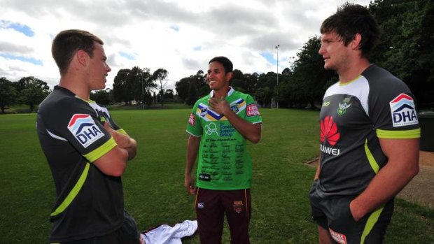 Usman Khawaja chats to Raiders players Sam Williams, left, and Jarrod Croker after receiving a signed Canberra jumper.