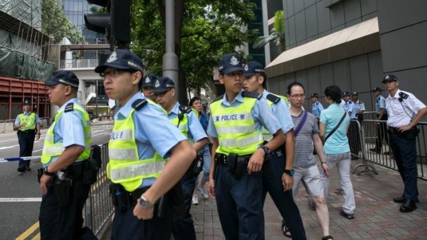 Hong Kong police patrol the streets in front of their headquarters.