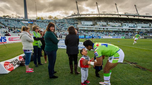 
Canberra Raiders' Sia Soliola gives his son a kiss as the mothers watch on the sideline warm-up.
