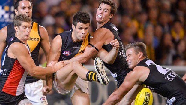 Trent Cotchin defies the close attention of a trio of Saints
