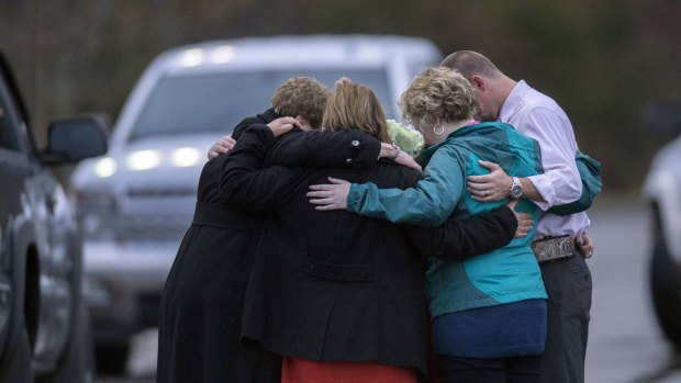 People gather to pray near the scene where two school buses collided in Knoxville, Tennessee.