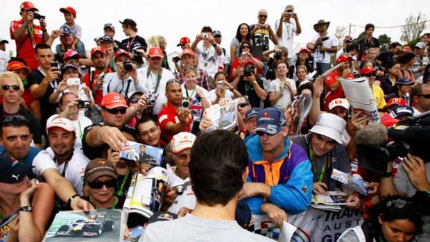 Australia's Mark Webber signs autographs for diehard fans including Brett Wheeler in blue jacket.