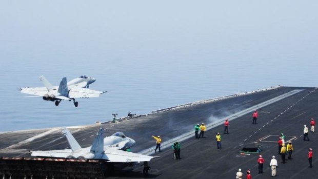 A F/A-18E Super Hornet takes off from aircraft carrier USS George H.W. Bush in the Gulf, as US air strikes in Iraq begin.