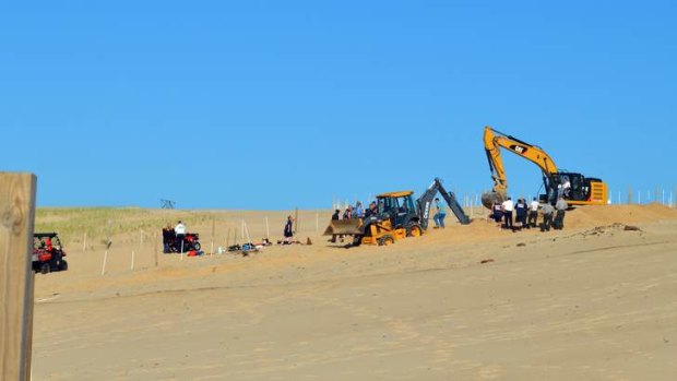 Michigan City firefighters, police, and first responders dig through a sand dune at Mount Baldy near Michigan City, Indiana for a missing 6-year-old-boy who fell into a hole.