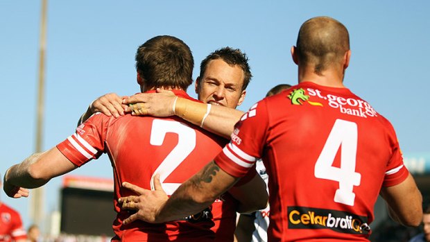Nathan Fien embraces Brett Morris of the Dragons after the winger's try against the Warriors in Wollongong.