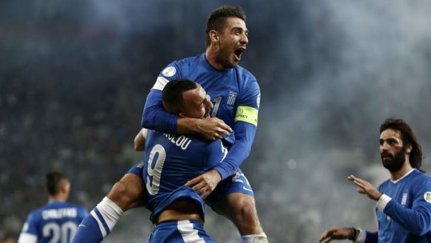 Jaw-dropping: Greece's Kostas Katsouranis, top, congratulates Kostas Mitroglou for his goal against Romania.