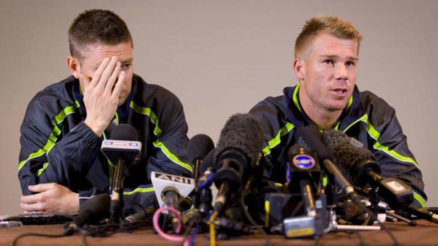 Out of action: Michael Clarke and David Warner face the media after Warner's pub fracas.