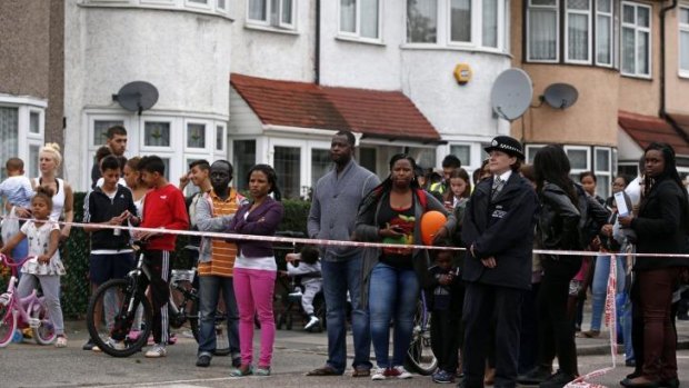 Horrific crime: residents watch on after a woman was beheaded.