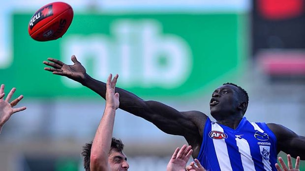 Majak Daw reaches over a pack in a marking attempt.