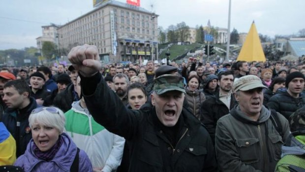 People shout slogans during a rally in the Independence Square in Kiev, Monday, April 14, 2014. Ukraine's acting president urged the United Nations on Monday to send peacekeeping troops to eastern Ukraine, where pro-Russian gunmen kept up their rampage of storming and occupying local government offices, police stations and a small airport.