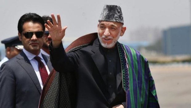 Afghan President Hamid Karzai waves after arriving for the swearing in ceremony of India's Prime Minister elect Narendra Modi in New Delhi, India.