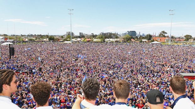 The Bulldogs look out to the crowd during the grand final celebrations at Whitten Oval. 
