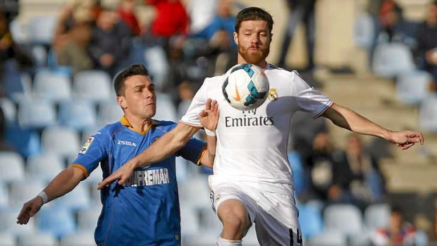 Eye on the ball: Real's Xabi Alonso in action with Getafe's Colunga.
