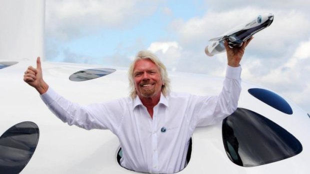 Sir Richard Branson poses with his Virgin Galactic Space craft at Britain's Farnborough International Airshow in 2012.