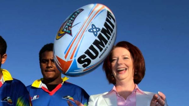 Eye on the ball . . . Julia Gillard meets junior rugby league players in Cairns yesterday.