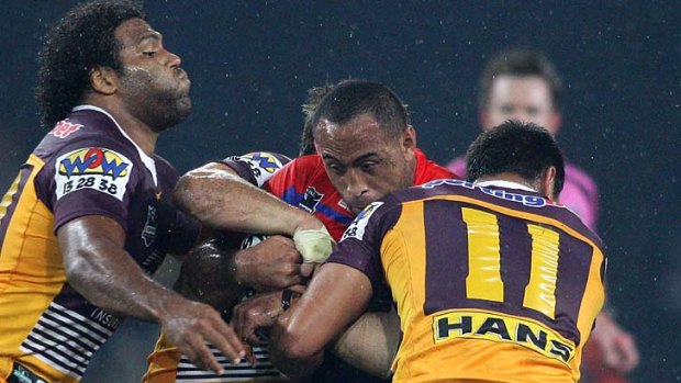 Antonio Kaufusi of the Knights feels the full might of a Broncos defence.