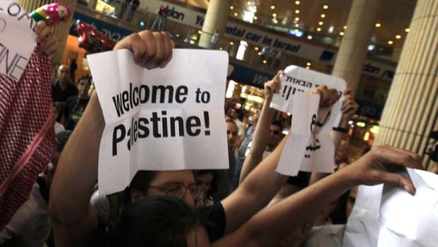 Activists hold signs during a demonstration at Ben Gurion International Airport ... six were later arrested.