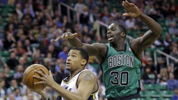 Utah Jazz rookie Trey Burke goes to the basket as Boston Celtics opponent Brandon Bass defends in Salt Lake City.