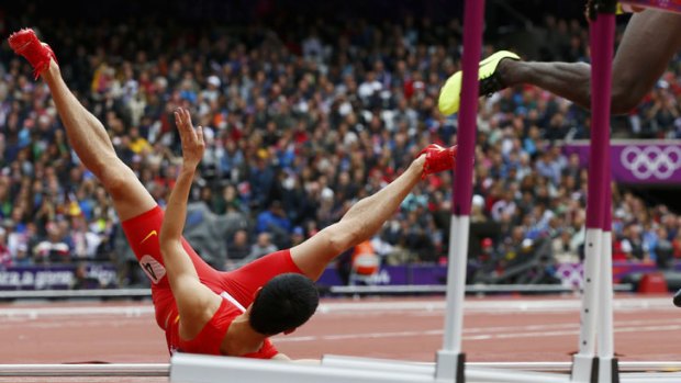 China's Liu Xiang falls onto the track during his men's 110m hurdles round one heat at the London 2012 Olympic Games at the Olympic Stadium.