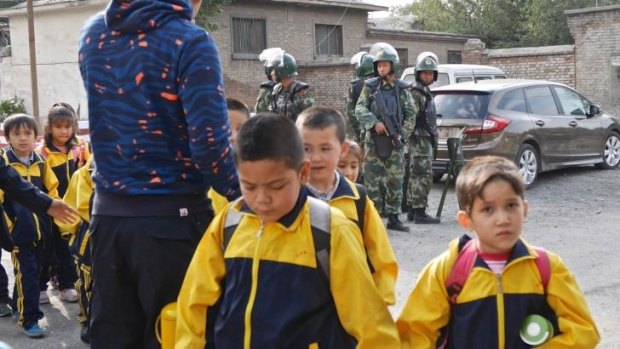 Children leave school under armed guard in Urumqi.