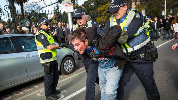 Police lead a member of the United Patriots Front  away during the July 18 rally. 