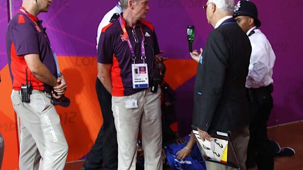 A man is held down by police after being arrested for throwing  a bottle just before the start of the 100m.