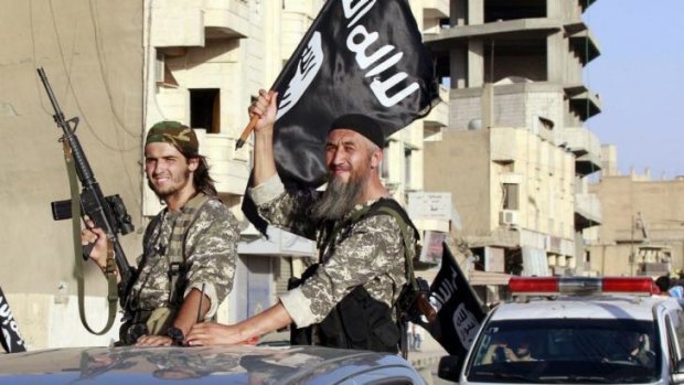 Militant Islamist fighters wave flags in Syria.
