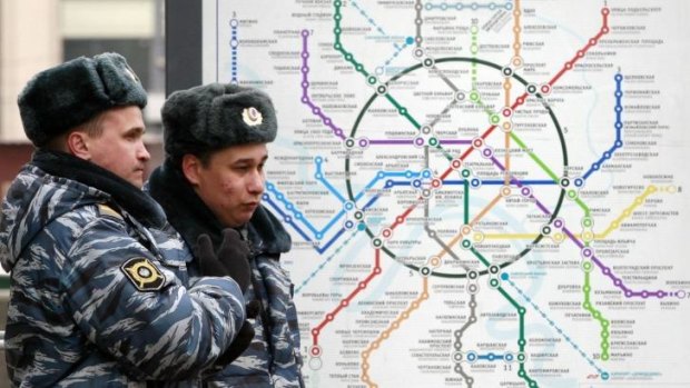 Cracking down on "Spice" dealers: Russian police stand near a map of the Moscow metro transport system.