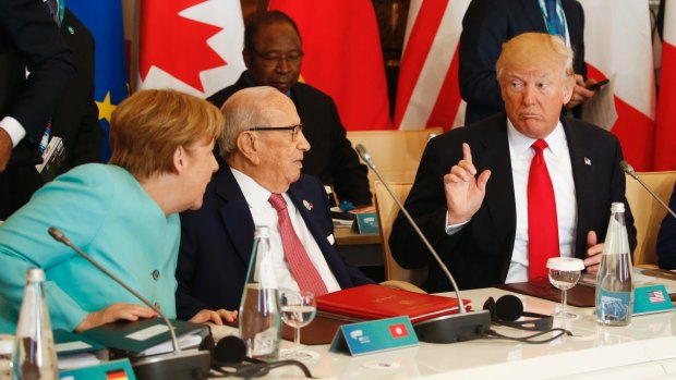 US President Donald Trump talks to German Chancellor Angela Merkel at the G7 summit.
