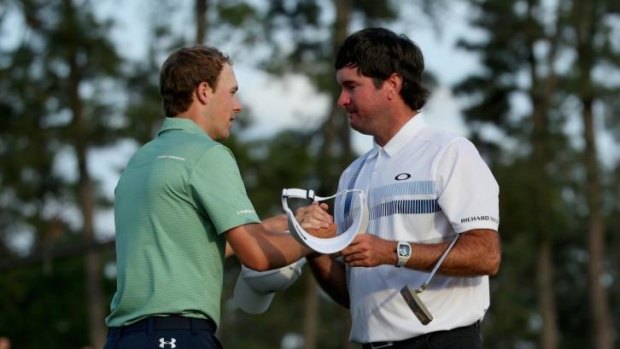 Bubba Watson of the United States shakes hands with Jordan Spieth on the 18th green.