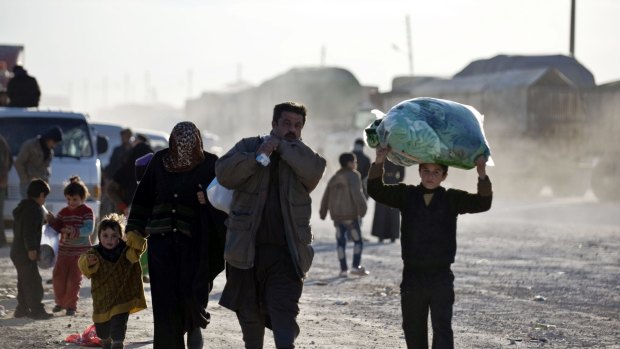 Syrians walk towards the Turkish border at the Bab al-Salam border gate in Syria.