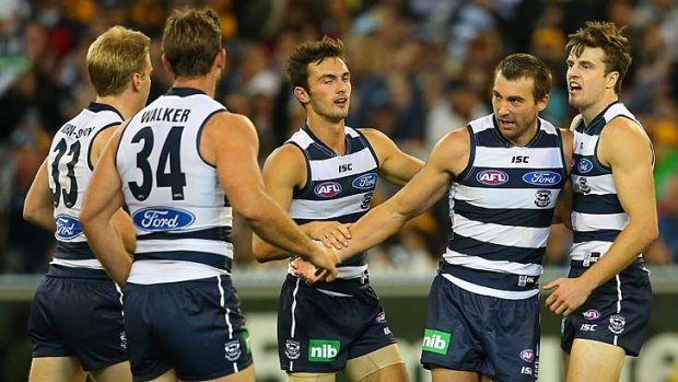 Geelong's Corey Enright is congratulated by teammates after kicking a goal.