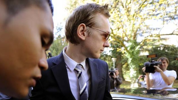 A November 4, 2010, file photo shows Julian Assange next to a bodyguard as he leaves after a press conference at the Geneva Press Club.