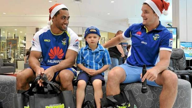 Raiders players Bill Tupou and Jarrod Croker, with four-year-old Hayden Fox of Calwell on Monday.