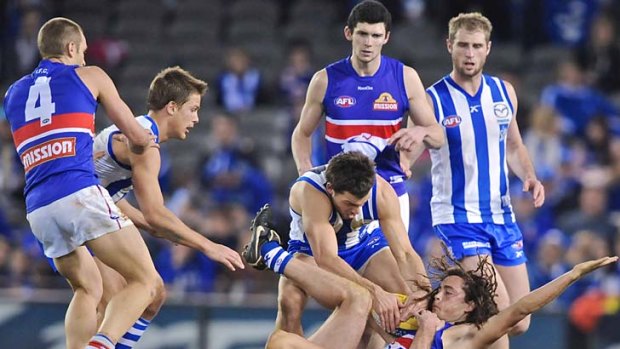 Got him: Bulldog Luke Dahlhaus pleads his innocence after being gang-tackled by North Melbourne players at Etihad Stadium last night.