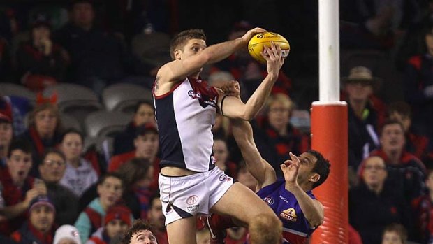 High point: Melbourne's Ricky Petterd soars for a spectacular mark last night at Etihad Stadium. It was a rare highlight for the Demons.