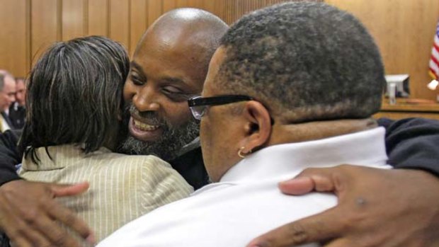 Free after nearly 30 years ... Raymond Towler, centre, hugs his sister Debbie and his brother Clarance.