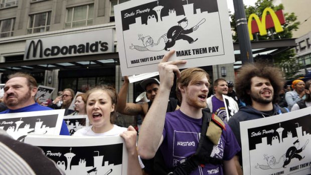 Demonstrators demand higher pay for fast-food workers near a McDonald's restaurant in Seattle.