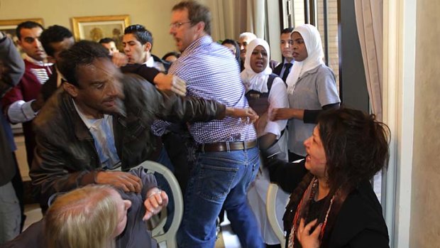 Desperate plea ... Ms Obeidi, centre, reacts as she is grabbed by a Libyan official, preventing members of the foreign media from reaching her.