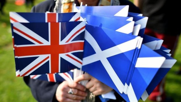 A "no" vote supporter holds Union and Scottish flags ahead of the Grand Orange Lodge of Scotland march in Edinburgh.