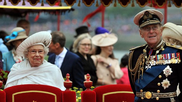 Queen Elizabeth II  and  Prince Philip watch the proceedings  from the royal barge.